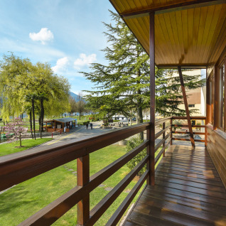 Udsigt fra en balkon i Campofelice Village Camping - Chalet Lago Maggiore med sø, grønne træer og bjerge.