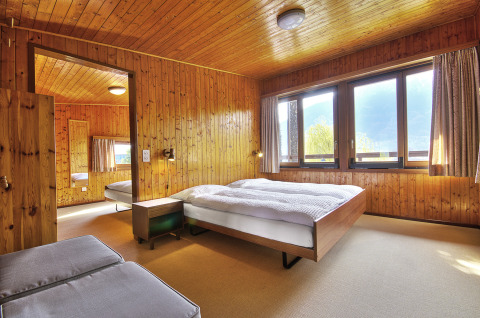 Interieur van een lichte slaapkamer met houten wanden in Campofelice Village Camping - Chalet Lago Maggiore.