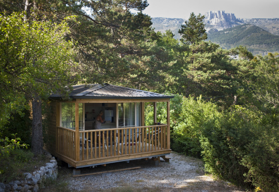 En hyggelig glampinghytte i træ blandt grønne træer ved Huttopia Gorges du Verdon, glamping i Alpes-de-Haute-Provence.