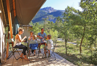 Famiglia fa colazione sulla terrazza di una tenda glamping a Huttopia Gorges du Verdon, Alpi dell'Alta Provenza.