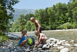 Kinderen spelen bij een rivier bij Huttopia Gorges du Verdon glamping in de Alpes-de-Haute-Provence.
