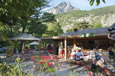 Das Café und die Terrasse im Huttopia Gorges du Verdon Glamping, umgeben von Bergen und Natur in den Alpen.