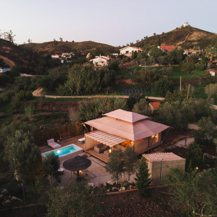 Lodge Lua glamping accommodatie met zwembad in Algarve, Portugal, omgeven door heuvels en natuur.