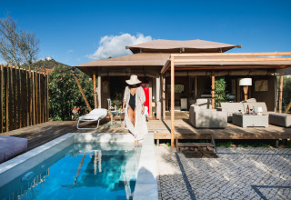 Glamping Lodge Lua en Algarve, Portugal, con piscina privada, terraza de madera y cómoda sala exterior.