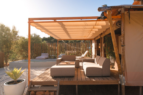 Terraza al aire libre en Lodge Lua – Portugalvillas Glamping Algarve con sofás modernos y pérgola de madera.