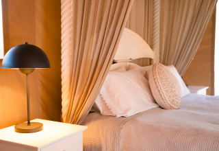 Knusse glamping slaapkamer in Lodge Lua, Portugalvillas - Glamping Algarve met moderne lamp en zachte gordijnen.