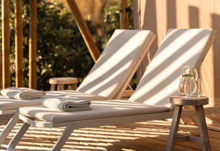 Comfortabele ligstoelen met handdoeken en waterkan op houten tafel bij Lodge Lua - Portugalvillas Glamping Algarve.