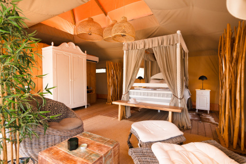 Alojamiento de glamping Lodge Lua en Algarve, Portugal, con cama con dosel y decoración elegante de madera.