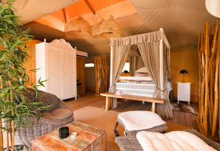Alojamiento de glamping Lodge Lua en Algarve, Portugal, con cama con dosel y decoración elegante de madera.