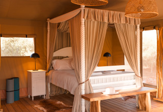Alojamiento de glamping acogedor en Lodge Lua, Portugalvillas, Glamping Algarve con cama con dosel y luz natural.