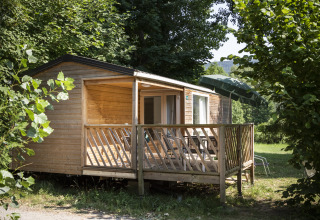 Houten glamping accommodatie bij Huttopia Millau - Glamping Aveyron, omringd door weelderig groen.