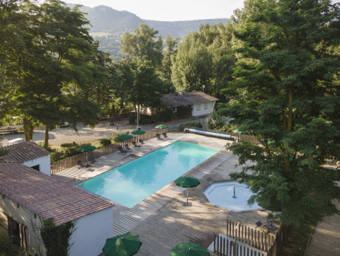 Billede af swimmingpool og afslapningsområde omgivet af natur på Huttopia Millau - Glamping Aveyron.