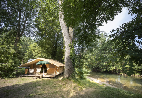 Alojamiento glamping en Huttopia Millau - Glamping Aveyron con tienda junto al río y entorno boscoso.