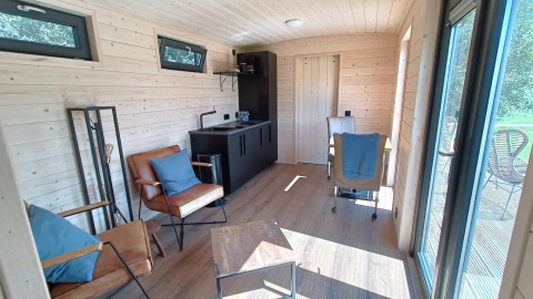 Indvendig udsigt over en rummelig glampingvogn i træ på Stadslandgoed De Heicohoeve Pipowagens Gelderland.