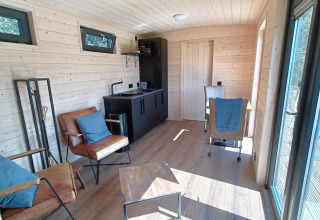 Indvendig udsigt over en rummelig glampingvogn i træ på Stadslandgoed De Heicohoeve Pipowagens Gelderland.