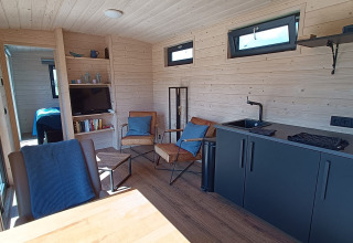 Intérieur moderne de glamping à Pipowagens Gelderland au Stadslandgoed De Heicohoeve, espace salon douillet.