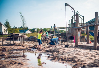 Kinderen spelen en graven in het zand bij een speelplaats in vakantiepark Ackersate, Gelderland, Nederland.