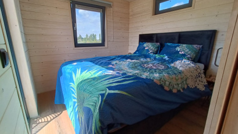 Chambre de glamping à Stadslandgoed De Heicohoeve - Pipowagens Gelderland avec literie bleue décorative.