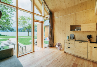 Innenraum einer Glamping Eco Lodge am Millstätter See in Österreich, mit heller Holzeinrichtung und Seeblick.