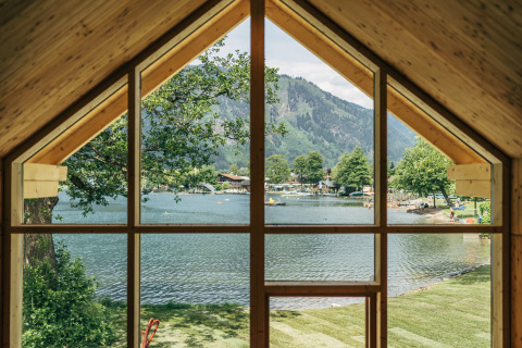 Zicht vanuit Eco Lodges Millstätter See in Oostenrijk, op het meer, bergen en het kampeerterrein.