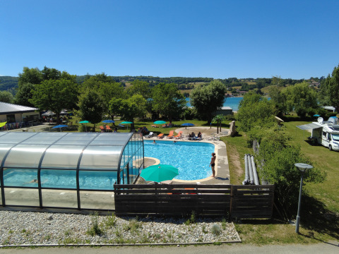 Buitenzwembad en overdekt bad bij Camping Détente et Clapotis - Glamping Auvergne-Rhône-Alpes, omgeven door natuur.