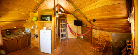 Interieur van glampingaccommodatie bij Camping Détente et Clapotis, Auvergne-Rhône-Alpes, met keukenblok.