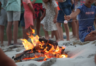 Des enfants font griller des guimauves au feu de camp lors du glamping au Whaka Lodge dans le Sud de la France.