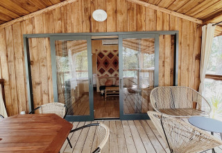 Houten terras met moderne zitjes bij Whaka Lodge Glamping Zuid-Frankrijk, omgeven door de natuur.