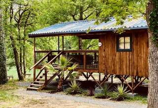 Cabane en bois de glamping au Whaka Lodge, Sud de la France, entourée d’arbres verdoyants et nature.