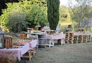 Buffet-Tische im Freien bei Whaka Lodge Glamping in Südfrankreich, umgeben von grüner Natur.