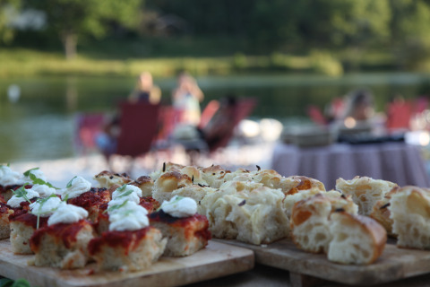 Pane fresco servito all’aperto vicino al lago a Whaka Lodge glamping, immerso nella natura.