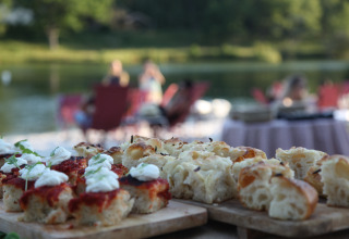 Udendørs madoplevelse ved søen på Whaka Lodge glamping, med friskbagt brød og naturstemning.