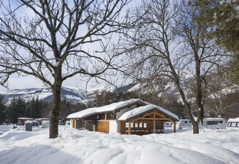 Winter glamping at Huttopia Winter Chalets – Bourg St Maurice, Savoie, with snow, trees, and caravans.