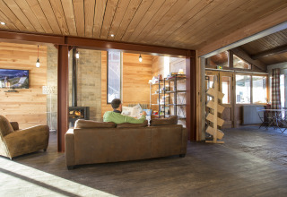 Salon convivial en bois dans les Huttopia Winter Chalets Bourg St Maurice, hébergement glamping en Savoie.