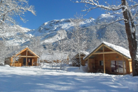 Schneebedeckte Holzhütten im Huttopia Winter Chalets – Vallouise, Glamping in den französischen Alpen.