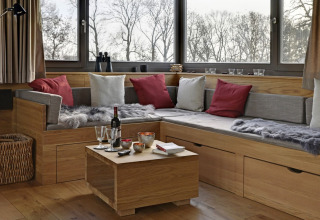 Cozy glamping lounge at Elbinselhof Krautstrand Boomhutten Nedersaksen with wood decor and comfy seating.