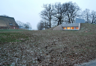 Glamping-accommodatie Elbinselhof Krautstrand - Boomhutten Nedersaksen, deels ingebouwd in een grasheuvel.