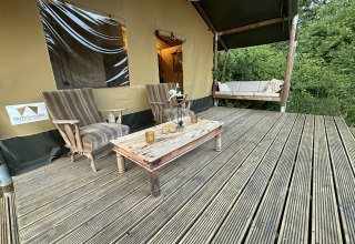 Buitenveranda met comfortabele stoelen en tafel bij Koakelbonts Lovenest - Safaritent Gelderland.