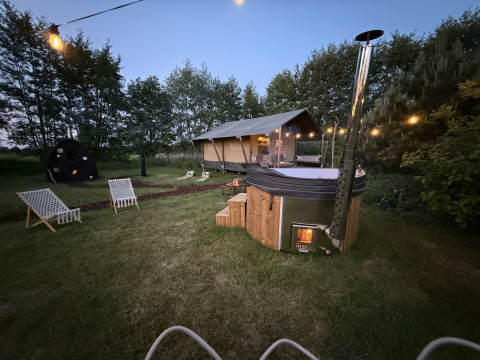 Glamping-ophold ved Koakelbonts Lovenest med safaritelt, udendørs spabad og hyggelig belysning i Gelderland.