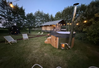 Alojamiento glamping Koakelbonts Lovenest con tienda safari, bañera caliente y luces en Gelderland, Países Bajos.