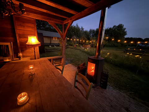 Gemütliches Glamping bei Koakelbonts Lovenest - Safaritent Gelderland mit Lichterkette und Kaminofen.