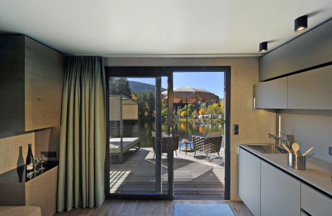 Moderne glampingaccommodatie bij Nature Resort Natterer See - Floating Homes Tirol met terras aan het meer.
