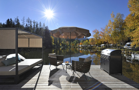 Hébergement glamping flottant au Nature Resort Natterer See, avec terrasse, vue sur le lac et barbecue au Tyrol.