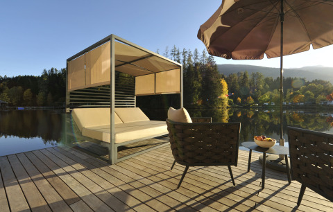 Flydende hjem på Nature Resort Natterer See i Tirol med luksuriøs terrasse, søudsigt og moderne møbler.
