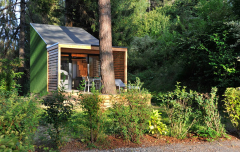 Alloggio glamping moderno Tiny House Tirol al Nature Resort Natterer See, immerso nel verde rigoglioso.