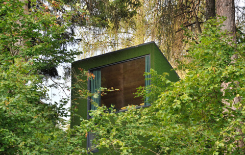 Tiny House Tirol bij Nature Resort Natterer See, glampingaccommodatie verscholen tussen bomen in de natuur.