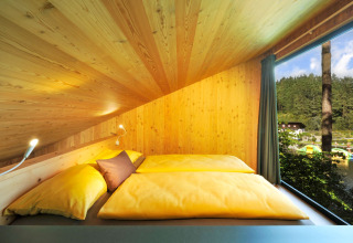 Glamping al Nature Resort Natterer See - Tiny House Tirol con letto accogliente, legno e vista lago/bosco.