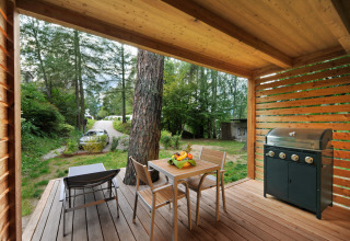 Glamping-Unterkunft Nature Resort Natterer See - Tiny House Tirol mit Holzterrasse, Tisch und Grill.