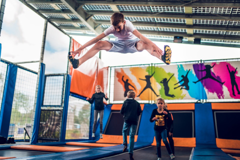 Kinderen springen en spelen op trampolines in het indoor trampolinepark van Holiday park Ackersate.