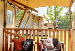 Terrasse glamping confortable avec meubles en bois et coussins, Frei wie der Wind - Safaritenten, Baltique.